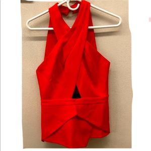 Sleeveless halter red top with zipper closure on the back and buttons at neck.